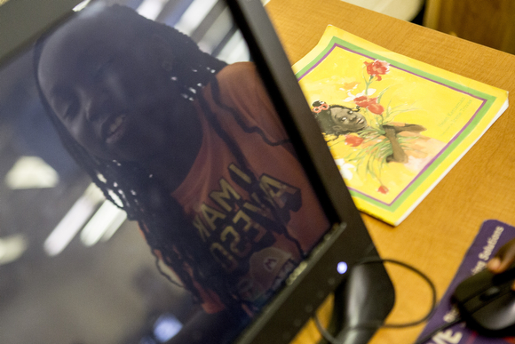 Rayjenae, 7, is reflected in the computer she’s using at the Cornelia Crenshaw Library. 