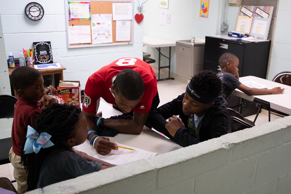 Timothy Williams, who works mostly with high school students, assists some of the kids with their homework at Oasis of Hope. (Brandon Dahlberg)