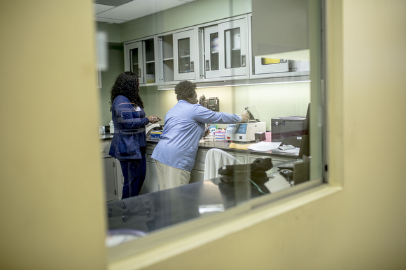  Lab technicians work on samples at the Guthrie Primary Care Clinic in Smokey City. 