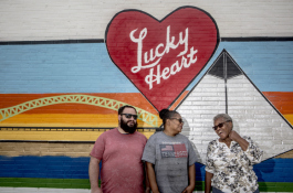 Jeremy Stein, general manager for Lucky Heart Cosmetics stands with Bennie Franklin, an employee of 33 years, and Olivet Montgomery, an employee of 52 years, by the mural outside the company's new storefront on Dr. Martin Luther King Boulevard.