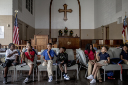 Children in the third grade group sit in the chapel during a reading lesson at the Emmanuel Center.