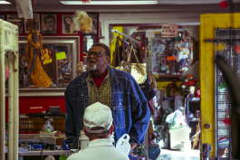 A customer looks around the store as he speaks with the owner of the Summer Outlet thrift store. (Natalie Eddings)