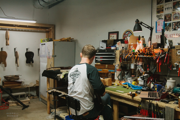  Hans Hilboldt at his workbench working on the strings of a guitar