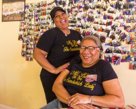 Stacy Bizzard (L) and her mother, Bonnie Harris, are co-owners of Ms. B's Sub Shop. They pose here in front of a wall of photos of satisfied customers. (Ziggy Mack) 
