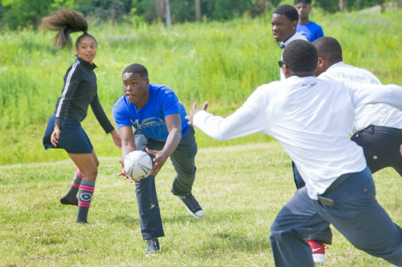 Students from Power Center Academy High School's rugby teams demonstrate the sport at future site of the school's official rugby field.
