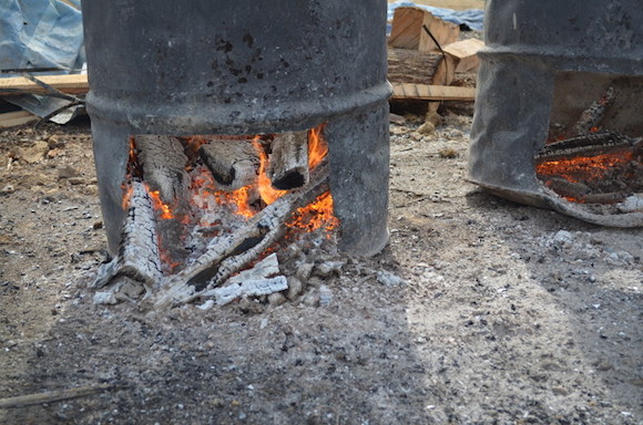 Wood burns down to make coals in a barrel outside the smokehouse at Latham's Meat Company in Jackson, Tenn.