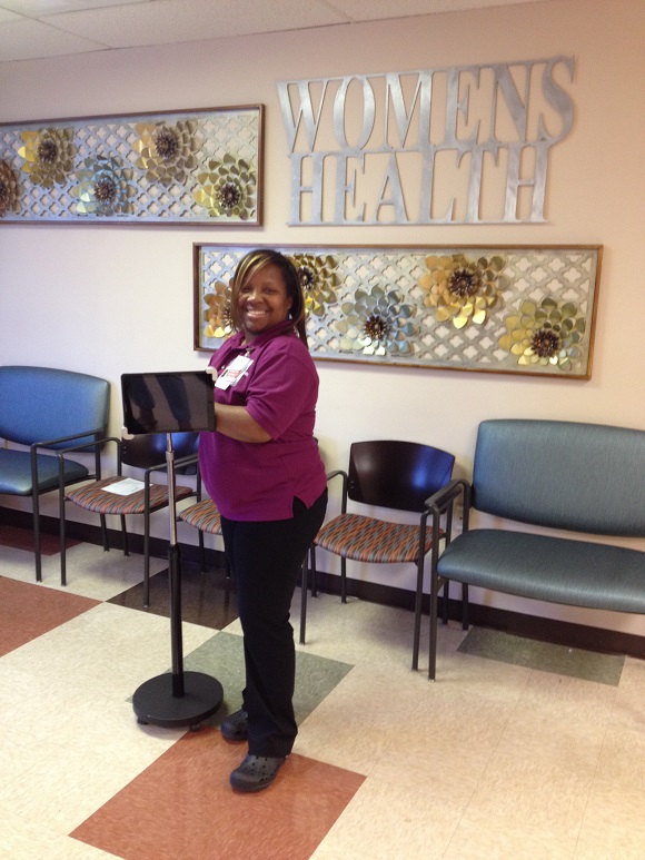 Venetia Bennett displays one of the kiosks used to gather patient feedback at the Women's Health Center of Christ Community Health Services.