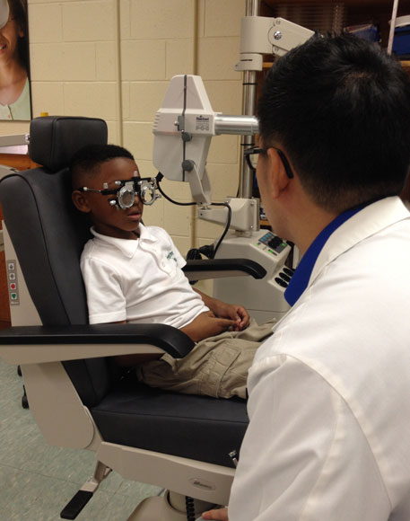 An SCO staff member tests a young student's eyesight