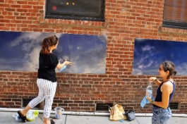 Eszter Sziksz (L) and Stephanie Cosby (R) work on "Skywalker", an art installation in Barboro Alley.