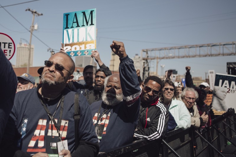 Teddy McNeal (center) raises his fist during Common’s performance outside the AFSCME Hall. McNeal traveled from Kinston, NC with his Machinists union. (Andrea Morales/MLK50)