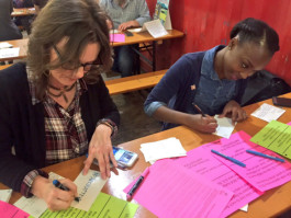 Christy Valentine (L) and  Kimberly Hooper-Taylor write postcards to legislators advocating for arts funding.