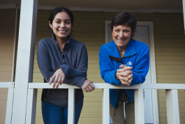 Magaly Cruz (L) and Joni Laney on the porch of a property that was previously blighted. The land trust worked with Neighborhood Preservation Inc. to report the house to Code Enforcement and within one month it was in compliance. (Ziggy Mack)