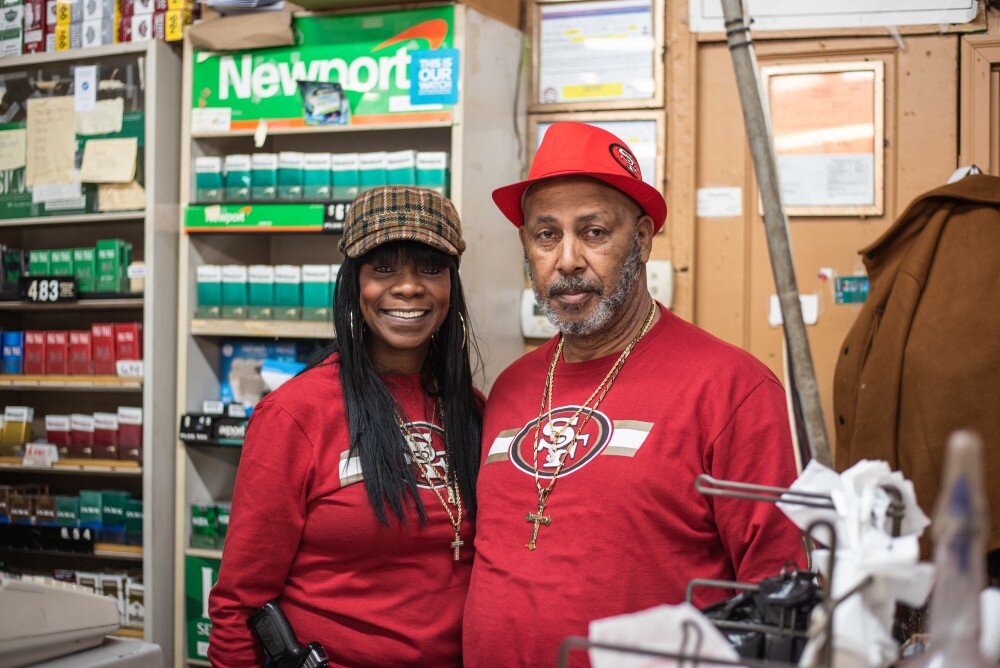 The owners of the Shop & Save pose behind the counter of their South Memphis corner store. (Malik Martin)