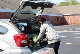 A volunteer with the Neighborhood Christian Center packs a family’s car with a week’s worth of meals. NCC is one of the organizations that has received funding from the Mid-South COVID-19 Regional Response Fund. (Submitted)