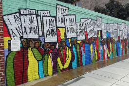 The "I'm a Man" mural was designed by rap artist Marcellous Lovelace in a modern graffiti style and installed by BLK75. It can be found on S. Main Street, close to the National Civil Rights Museum. It shows the Sanitation Workers Protest March on Mar