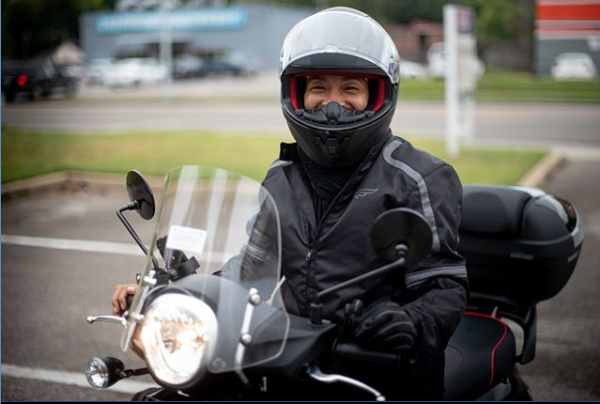 A rider, or Flyer, poses with a smile on a MyCityRide scooter. (MyCityRides)