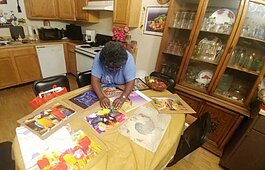 Derotha Payne-Obie mounts a recently completed puzzle at her dining room table. Prior to the pandemic, she attended the Lewis Senior Center. It closed in March under local and state mandates. (Tamara Cunningham)
