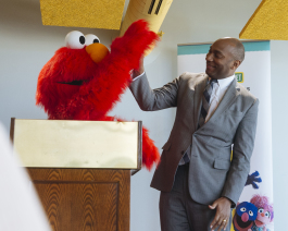 Shelby County Mayor Lee Harris high-fives Elmo at a December 4 press conference to announce a new partnership with Sesame Street in Communities. (Ziggy Mack)