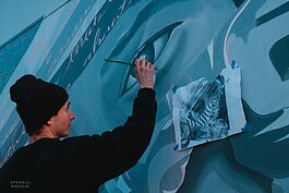 Brandon Marshall paints a temporary mural funded by UrbanArt Commission. (Averell Mondie)