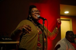 Tonya Dyson, local entrepreneur and founder of The Word sings between acts and encourages local artists to promote themselves and upcoming events. 