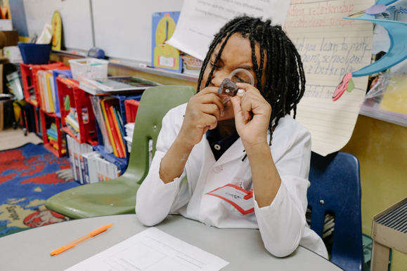 A student examines a rock during a science lesson in Dr. Collins's class. (Brandon Dahlberg)