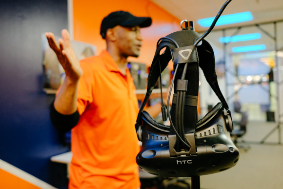 Charles Story Jr, owner of Game oN, demonstrates a VR headset. (Brandon Dahlberg)