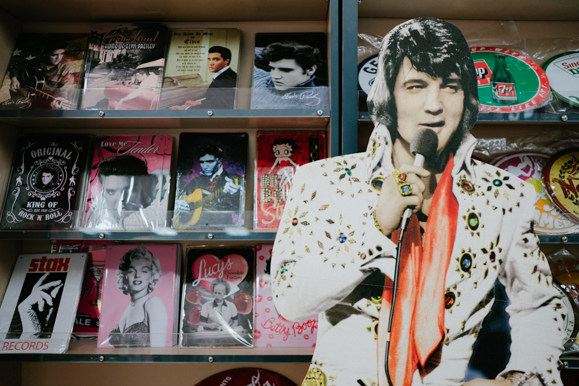 A cardboard Elvis display in front of various signs at Boulevard Souvenirs. (Brandon Dahlberg)