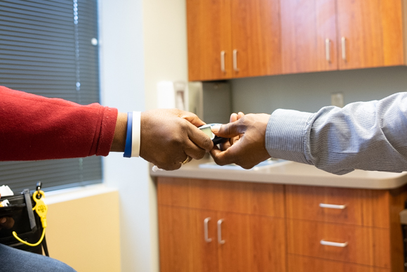 Betty Jones hands her blood glucose meter to her son Andre at an appointment with Meothdist South in Whitehaven. (Brandon Dahlberg)