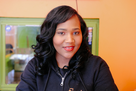 Quavisa Henderson, owner of ElectroLyfe, poses for a portrait behind the counter. (Brandon Dahlberg)