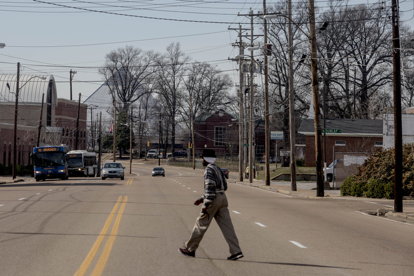 A man walks across Jackson Avenue near the edge  of the Smokey City neighborhood with Uptown.
