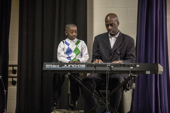 William Griffin and his son Joseph, 7, play the keyboard during Sunday service at Hope City Church in Caldwell-Guthrie's cafeteria in Smokey City. 