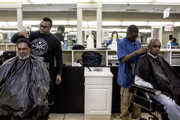 Jerome Pope (L) and Robert Coates (R) cut hair at The Barber School on Jackson Avenue in Klondike. 