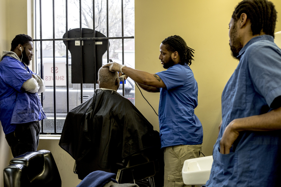 Torin Marshall gives Bill Candely a haircut at The Barber School on Jackson Avenue in Klondike. 