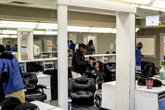  Quan Smith practices on a dummy head while at The Barber School on Jackson Avenue in Klondike. 