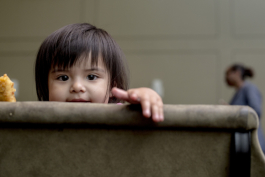 Azaylia Elias, 1, peeks out over a chair at the Operation Smart Child program at the Neighborhood Christian Center in Smokey City. 