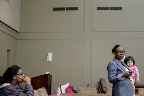  Joi Hibbler, an educator for Operation Smart Child, leads a conversation in the prenatal program for expectant mothers while holding Azaylia Elias, 1, a student's daughter at the Neighborhood Christian Center in Smokey City.