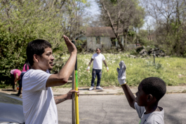 Jason Ayers high fives one of the kids that came out to help clean up empty lots along Randle Street in Klondike. Folks from the community organization Crowning Our Youth, Inc. an anti-violence and youth oriented group, worked to clean up vacant lots