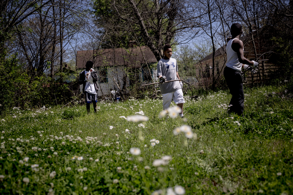 Kids clear an empty lot of branches and other debris. Folks from the community organization Crowning Our Youth, Inc. an anti-violence and youth oriented group, worked to clean up vacant lots along Randle Street in Klondike. 