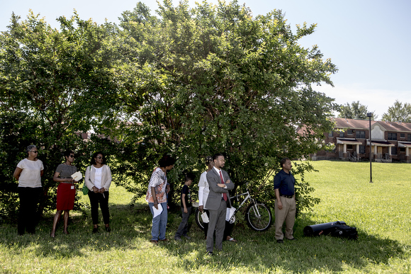 Folks attending the City of Memphis ceremony announcing the demolition of Foote Homes stand in the shade.