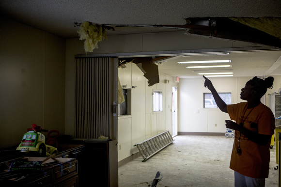 Barbara Nesbit walks through their damaged back trailer at the Vance Avenue Youth Development Center. The space served as their kitchen, dining and activity area and sustained a lot of damage after late May's storm. 