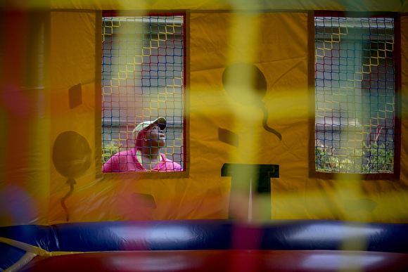 LaTonya Taylor, of Epic Bouncing, checks on a bounce house as it inflates while setting up in a client’s yard.