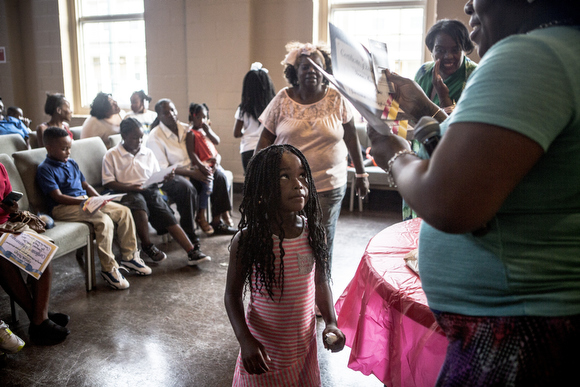 Shamaria Rogers walks up to collect her certificate for the hours of reading she accomplished over the summer.