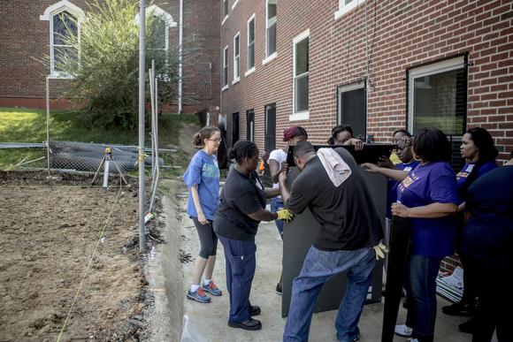 Volunteers work on setting up a foundation for a new playground on Wednesday morning at Circle of Success Learning Academy in South Memphis. 