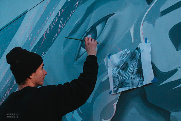 Brandon Marshall painting a recent temporary mural at the Crosstown strip.