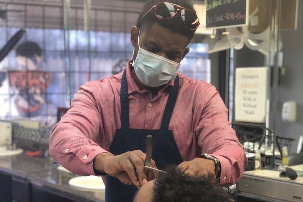 “Our young men need us and I let them know that I am here for them in any way I can,” says Jermaine Jackson, owner of Roots Barbershop.