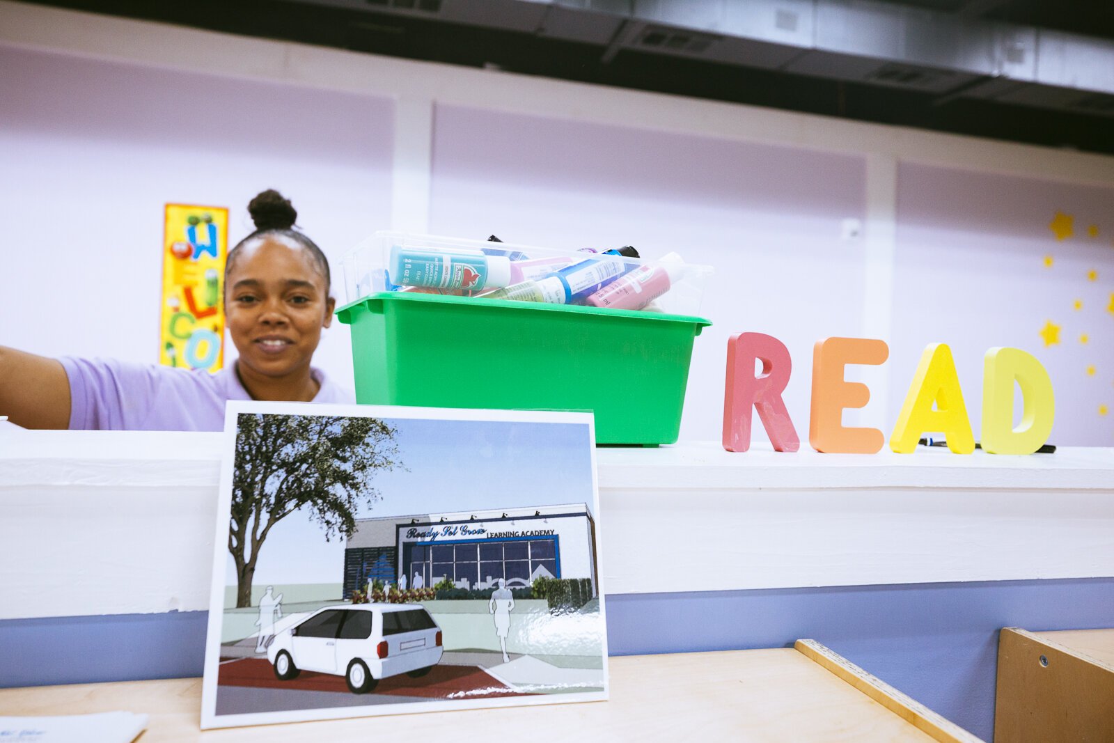 Instructor Akeidra WIlson stands in the bright and colorful Ready, Set. Grow Learning Academy. In the foreground, a rendering of Shamara Rogers' ultimate vision for her premier childcare academy. (Ziggy Mack)