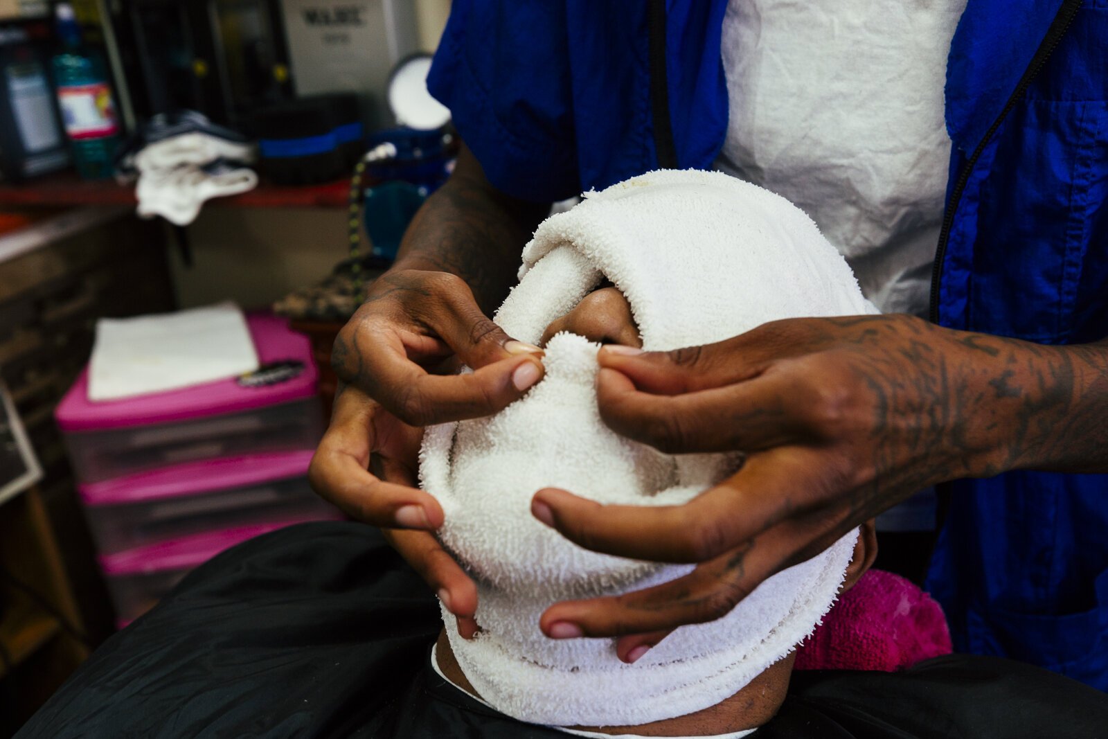 Wise Tardezia performs a single blade razor shave and towel facial treatment on Pedro Bateman at Presidential Barber Lounge in Madison Heights. (Ziggy Mack)