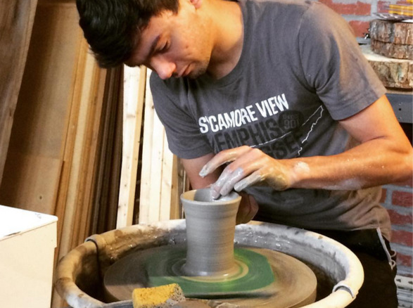 Belltower co-owner Micah Dempsey works on a pottery mug.