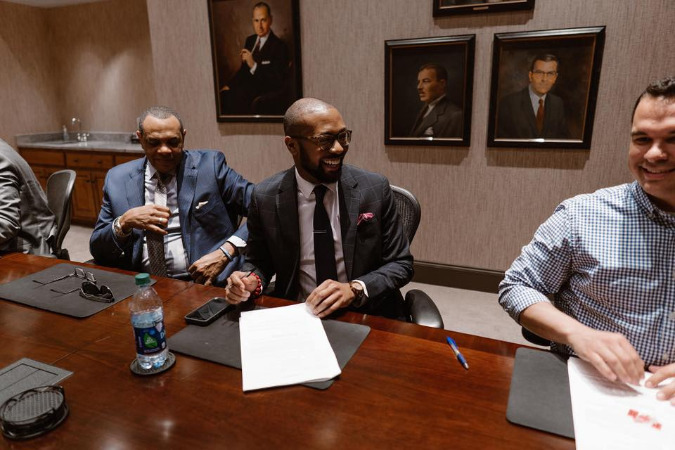 Former Grizzlies head coach Lionel Hollins (left), Edward Bogard, and Aaron Petree from Loeb Properties sign a ten-year lease for the new restauarant.