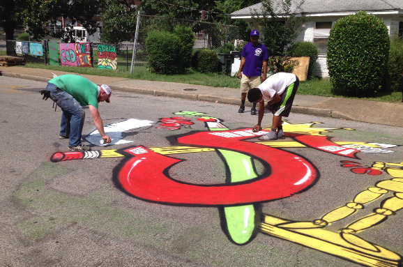 Artists Danny Shivers (left) and Trey Butler work on a freeform street painting marking Carpenter Art Garden's five-year anniversary.